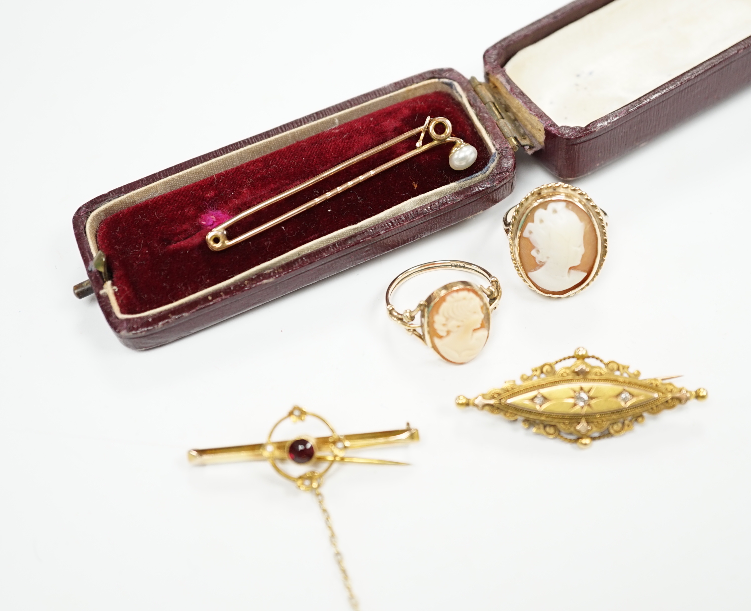 A late Victorian 15ct gold and three stone diamond chip set brooch, 43mm, an early 20th century yellow metal, garnet and seed pearl set bar brooch, two 9ct and oval cameo shell set rings and a yellow metal and cultured p